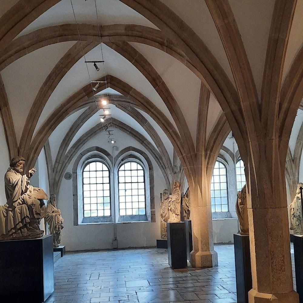 Stone vaulted ceiling, statues, windows, and tiled floor.  The image shows the interior of the Holy Cross Chapel in Schwäbisch Gmünd, Germany.